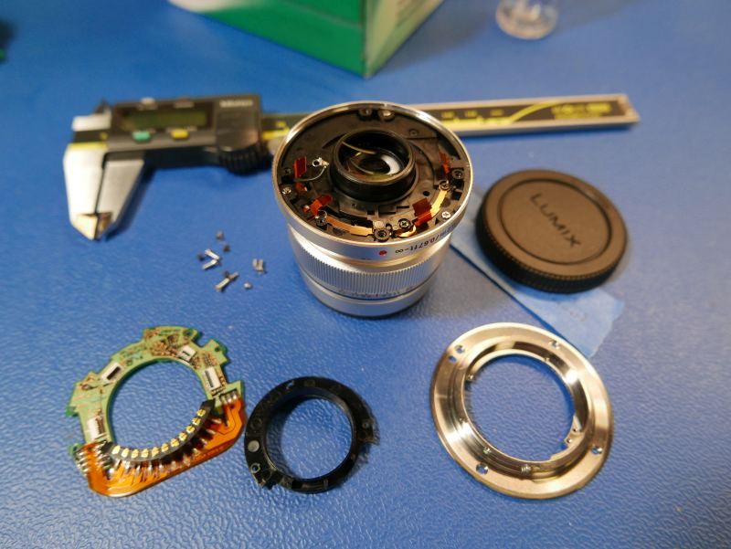 Rear of lens completely disassembled on work table.